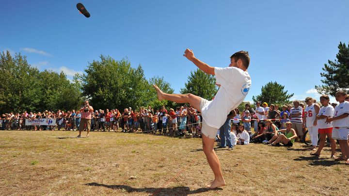 Un jeune homme participe au tournoi mondial de lancer de tong, &agrave; Hourtin (Gironde). (ERIC DESPUJOLS / SUD OUEST / MAXPPP)