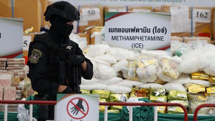 Un policier thaïlandais garde des sacs de méthamphétamines saisis, le 26 juin 2020 à Ayutthaya (Thaïlande). (SOPA IMAGES / CHAIWAT SUBPRASOM / SIPA)