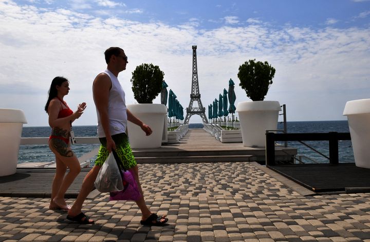 Vacationers in front of a miniature replica of the Eiffel Tower on June 19, 2023 on a beach in Yalta, Crimea annexed by Russia.  (OLGA MALTSEVA / AFP)