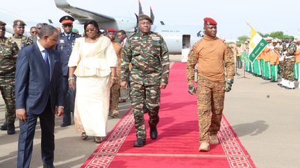 Le général nigérien Abdourahamane Tiani (à gauche) marche à côté de son homologue burkinabé, le capitaine Ibrahim Traore (à droite), à son arrivée à Niamey, au Niger, le 5 juillet 2024. (- / AFP)