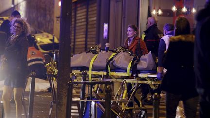 Un cadavre est transporté sur un brancard, dans le 10e arrondissement de Paris. (PHILIPPE WOJAZER / REUTERS)