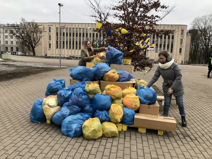 Katrina Berke et Karlina Zirne réceptionnent des sacs de vêtements pour les Ukrainiens, le 7 mars 2022, dans le centre-ville de Riga (Lettonie). (RAPHAEL GODET / FRANCEINFO)