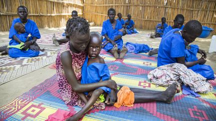 Des femmes tiennent dans leurs bras leurs enfants souffrant de malnutrition sévère, soignés dans un centre à Ganyiel, dans la province de&nbsp;Panyijiar, au Soudan du Sud, le 4 mars 2017. (ALBERT GONZALEZ FARRAN / AFP)