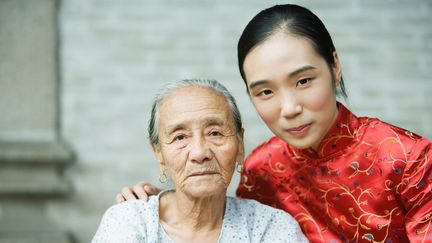 Une jeune femme vêtue de l'habit traditionnel chinois, à côté d'une femme âgée.&nbsp; (JAMES HARDY
 / MAXPPP)