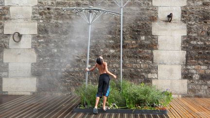 Un enfant se rafraîchit&nbsp;à Paris,&nbsp;pendant l'été 2013. (MANUEL COHEN / AFP)