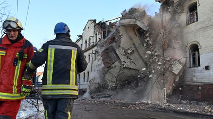 Des secouristes ukrainiens supervisent la destruction d'un bâtiment résidentiel partiellement détruit par un missile russe, le 17 janvier 2024, à Kharkiv (Ukraine). (SERGEY BOBOK / AFP)