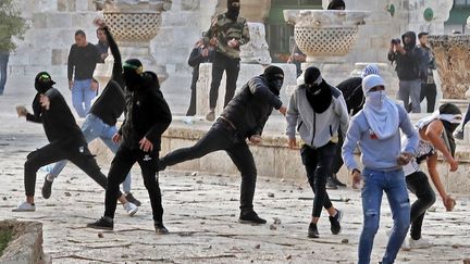 Des manifestants palestiniens affrontent la police israélienne dans l'enceinte de la mosquée Al-Aqsa de Jérusalem, le 22 avril 2022. (AHMAD GHARABLI / AFP)