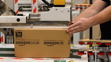 Un employ&eacute; pr&eacute;pare un colis dans un centre Amazon, &agrave; Peterborough (Royaume-Uni), le 28 novembre 2013. (ANDREW YATES / AFP)