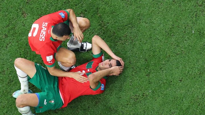 La déception des Marocains Romain Saïss (à gauche) et Achraf Hakimi après leur défaite contre la France en demi-finale de la Coupe du monde, au stade Al-Bayt d'Al-Khor (Qatar), le 14 décembre 2022. (GIUSEPPE CACACE / AFP)