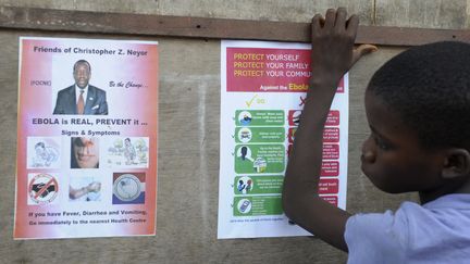 Un gar&ccedil;on lit des messages de pr&eacute;vention sur Ebola, le 17 ao&ucirc;t 2014 &agrave; Monrovia (Liberia).&nbsp; (REUTERS      )