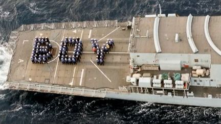 Des marins de la Royal Navy saluant la naissance du fils de William et Kate, en mer, le 22 juillet 2013. (APTN)