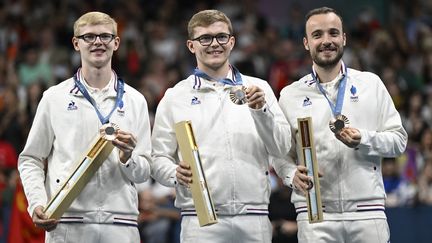 Félix Lebrun, Alexis Lebrun et Simon Gauzy sur le podium des Jeux olympiques de Paris, le 9 août 2024. (WANG ZHAO / AFP)