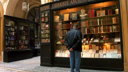 Un homme devant une vitrine de librairie à Paris le 25 mai 2015. (WILFRIED LOUVET / ONLY FRANCE)