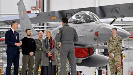 Le Premier ministre belge, Alexander De Croo, le président ukrainien, Volodymyr Zelensky, et la ministre de la Défense belge Ludivine Dedonder rencontrent des pilotes belges de F-16 à l'aéroport militaire de Melsbroek (Belgique), le mardi 28 mai 2024. (ERIC LALMAND / BELGA MAG / AFP)