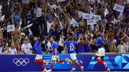 L'attaquant français Alexandre Lacazette (à gauche) célèbre après avoir marqué un but lors du match de football du groupe masculin A entre la France et les États-Unis dans le cadre des Jeux Olympiques de Paris 2024 au Stade de Marseille le 24 juillet 2024. (CLEMENT MAHOUDEAU / AFP)