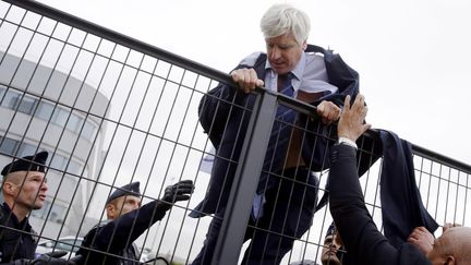 Pierre Plissonnier,&nbsp;directeur de l'activité long courrier d'Air France, est évacué par la police après que plusieurs centaines de salariés de la compagnie ont interrompu le Comité central de s'entreprise qui se tenait à Roissy-en-France (Val-d'Oise), le 5 octobre 2015. Les manifestants, qui ont déchiré sa chemise, protestaient contre un&nbsp;plan de restructuration de l'entreprise qui aurait menacé 2 900 emplois. (KENZO TRIBOUILLARD / AFP)