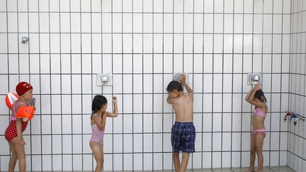 Vienne (Autriche), 37&deg;C, le 30 juin 2012. Les douches d'une piscine publique sont prises d'assaut par des enfants. (LISI NIESNER / REUTERS)