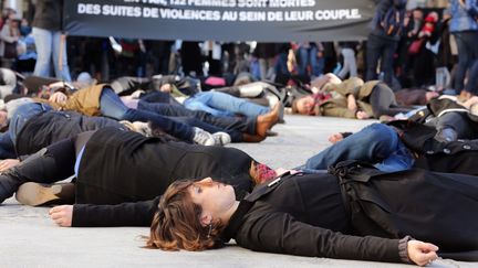 Des femmes s'allongent sur le sol pour dénoncer les violences subies par les femmes de la part de leur conjoint, lors d'une manifestation à Paris en novembre 2012. (THOMAS SAMSON / AFP)