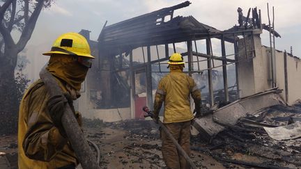 Les pompiers examinent une maison détruite alors qu'ils continuent de lutter contre l'incendie, à Los Angeles (Californie, Etats-Unis), le 9 janvier 2025. (JASON RYAN / ZUMA PRESS WIRE / SHUTT / SIPA)