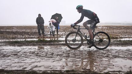 L'Italien Daniel Oss défie la boue lors de Paris-Roubaix le 3 octobre 2021. (ANNE-CHRISTINE POUJOULAT / AFP)