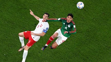 L'attaquant polonais Robert Lewandowski, au duel avec le Mexicain Edson Alvarez, lors de Mexique-Pologne le 22 novembre 2022. (KIRILL KUDRYAVTSEV / AFP)