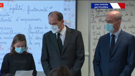 Jean Castex, Premier ministre et Jean-Michel Blanquer, ministre de l'Education nationale, regardent des élèves lirent la lettre aux instituteurs et institutrices de Jean Jaurès, dans une école de Conflans-Sainte-Honorine (Yvelines), le 2 novembre 2020. (CAPTURE ECRAN / OUVREZ LE 1 / FRANCEINFO (CANAL 27))