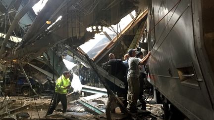 Les employés de la gare accourrent après le déraillement d'un train, le 29 septembre 2016, en gare d'Hoboken (Etats-Unis).&nbsp; (PANCHO BERNASCONI / GETTY IMAGES NORTH AMERICA / AFP)