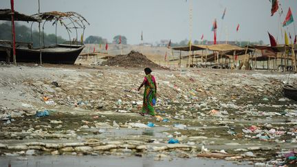 Une femme marche sur la rive polluée du Ganges à Sangam, en Inde, le 3 juin 2015. (SANJAY KANOJIA / AFP)