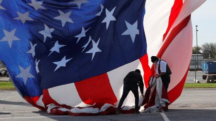 Des personnes accrochent un drapeau des Etats-Unis le jour du vote pour la présidentielle américaine à Wilmington (Delaware), le 3&nbsp;novembre 2020. (SHANNON STAPLETON / REUTERS)