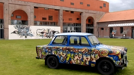 Des fragments du Mur de Berlin mais aussi trois Trabant, voiture emblamétique de l'ex-RDA, ont été décorés par des artistes de street art
 (France 3 Culturebox)