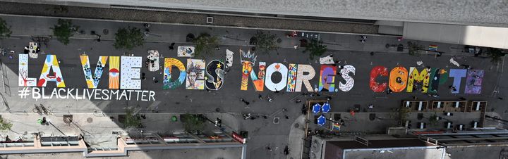 La fresque "La vie des noir.e.s compte" peinte au sol dans le quartier de Ste Catherine au centre de Montréal le 15 juillet 2020. (ERIC THOMAS / AFP)