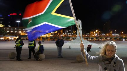 Une jeune fille brandit le drapeau de l'Afrique du Sud devant la mairie du Cap &agrave; la m&eacute;moire de l'ancien pr&eacute;sident Nelson Mandela, le 6 d&eacute;cembre 2013. (MIKE HUTCHINGS / REUTERS)