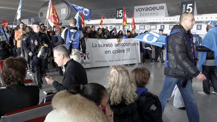 Le personnel des soci&eacute;t&eacute;s de s&ucirc;ret&eacute; de l'a&eacute;roport Roissy-Charles de Gaulle (Val-d'Oise)&nbsp;manifeste devant les passagers, le 17 d&eacute;cembre 2011. (PH LAVIEILLE&nbsp;/ LE PARISIEN / MAXPPP)