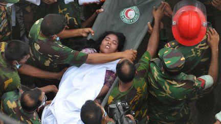 Les secours &eacute;vacuent, le&nbsp;26 avril 2013,&nbsp;une survivante de l'immeuble effondr&eacute; dans la banlieue de&nbsp;Dacca (Bangladesh). (AFP)