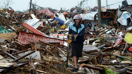 Un homme hagard marche dans les d&eacute;bris dans la ville ras&eacute;e de Tacloban (Philippines), le 10 novembre 2013 (NOEL CELIS / AFP)