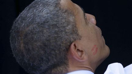 J-14 #TEAMOBAMA Le pr&eacute;sident am&eacute;ricain Barack Obama, dont la joue pr&eacute;sente une trace de rouge &agrave; l&egrave;vres, salue ses supporters en meeting &agrave; Delry Beach (Floride), le 23 octobre 2012. (PABLO MARTINEZ / AP / SIPA)