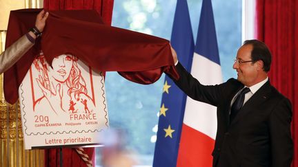 Le pr&eacute;sident Fran&ccedil;ois Hollande d&eacute;voile le nouveau timbre prioritaire, le 14 juillet 2013, &agrave; l'Elys&eacute;e, &agrave; Paris. (FRANCOIS MORI/AP)