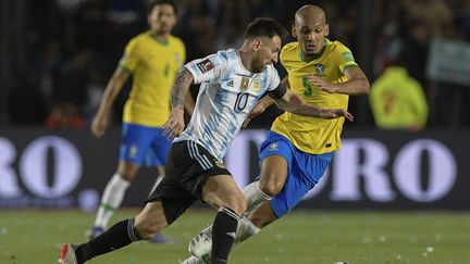 Lionel Messi tente de se défaire du marquage d'Edenilson, le 16 novembre à San Juan, en Argentine.&nbsp; (JUAN MABROMATA / AFP)