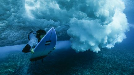 La Française Johanne Defay plonge sous une vague, lors d'une séance d'entraînement, le 26 juillet 2024. (BEN THOUARD / MAXPPP)