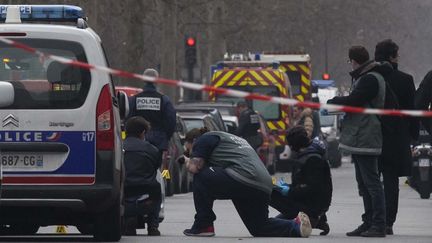 Des policiers enqu&ecirc;tent dans le 11e arrondissment de Paris apr&egrave;s l'attaque du si&egrave;ge du journal "Charlie Hebdo", le 7 janvier 2015. (GEOFFROY VAN DER HASSELT / ANADOLU AGENCY / AFP)