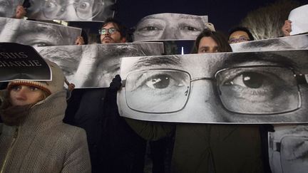 People hold up posters, which include Charlie Hebdo Editor Stephane Charbonnier (front), a cartoonist known as Charb, and Jean Cabut (back L), a cartoonist known as Cabu, during a vigil to pay tribute to the victims of a shooting, by gunmen at the offices of weekly satirical magazine Charlie Hebdo in Paris, in the Manhattan borough of New York January 7, 2015 (CARLO ALLEGRI / REUTERS)