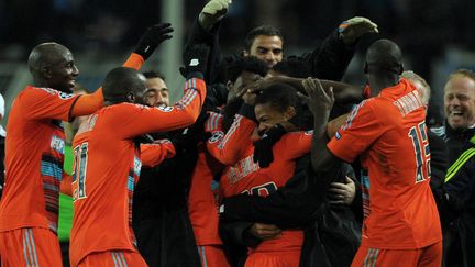 Les joueurs de l'OM c&eacute;l&egrave;brent la qualification en 8e de finale de la Ligue des Champions, au Signal Iduna Park de Dortmund, en Allemagne, le 6 d&eacute;cembre 2011. (JOHANNES EISELE / AFP)