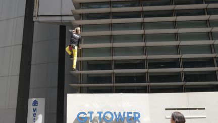 Alain Robert escalade une tour à Manille (Philippines) le 29 janvier 2019. (TED ALJIBE / AFP)