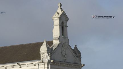 Un avion survole le mémorial de Notre-Dame-de-Lorette avec une banderole  "Hollande démission.fr"
 (LIONEL BONAVENTURE / AFP)