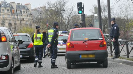 Des policiers contr&ocirc;lent des voitures afin de faire respecter le dispositif de circulation altern&eacute;e, lundi 17 mars 2014, &agrave; Paris. (YANN KORBI / CITIZENSIDE / AFP)