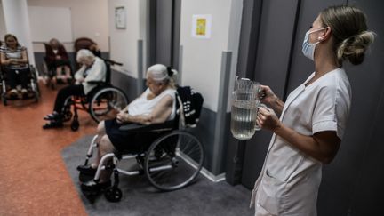 Un membre du personnel médical apporte de l'eau aux résidents du Ehpad de&nbsp;Bordeaux&nbsp;(Gironde), le 16 juin 2022, pendant une vague de chaleur en France. (THIBAUD MORITZ / AFP)