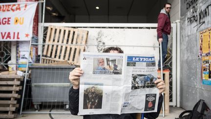 Un étudiant lit Le Figaro&nbsp;devant l'université Paris 8, le 24 mars.&nbsp; (BENJAMIN FILARSKI / HANS LUCAS)