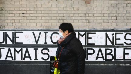 Une femme passe devant un mur sur lequel le collectif Collages féministes ont collé un slogan, à Paris, le 4 novembre 2020.&nbsp; (JEANNE FOURNEAU / HANS LUCAS / AFP)