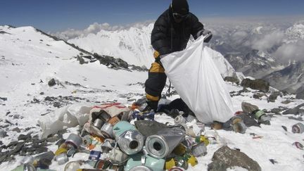 Un sherpa ramasse des d&eacute;chets sur le mont Everest, le 23 mai 2010.&nbsp; (NAMGYAL SHERPA / AFP)