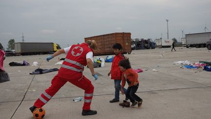 &nbsp; (Sur l'immense parking de l'ancienne zone douanière à Nickelsdorf, en Autriche, des enfants réfugiés jouent au ballon avec un membre de la Croix Rouge avant de rejoindre en bus la petite gare du village © Radio France / Jean-Marie Porcher)